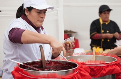 Woman serving Mazamorra morada, a lima Street food