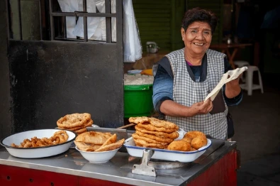 Woman preparing picarones , a tipical street food in Lima